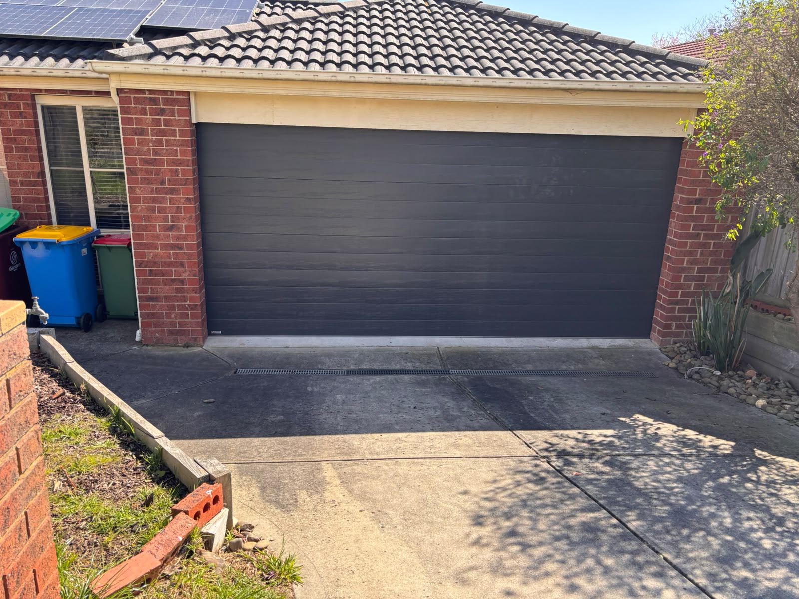 Dark sectional garage door on a Melbourne brick home